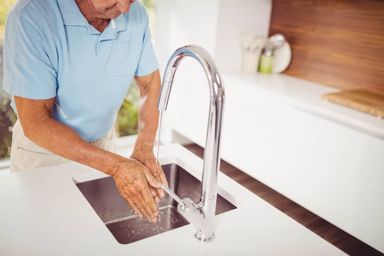 Senior man washing his hands, helping to maintain good personal hygiene.