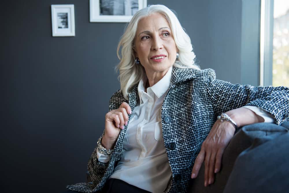 A senior woman in business casual poses for a photo