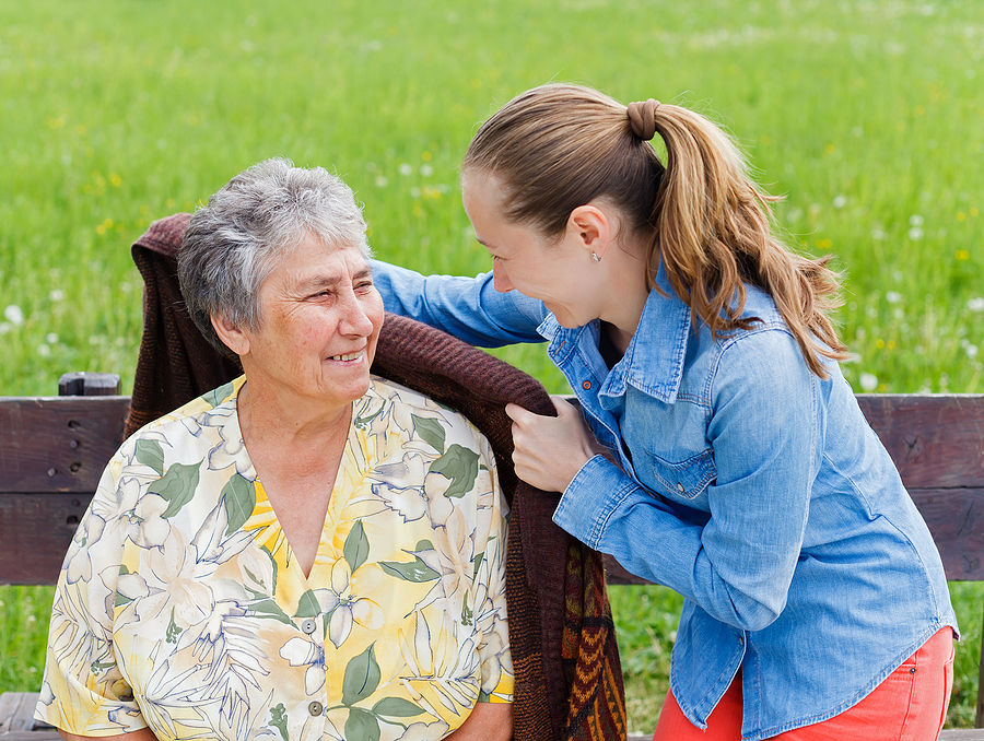 Young girl wrap her mother with a warm sweater