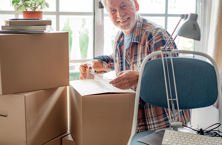 Senior Man taping a moving box