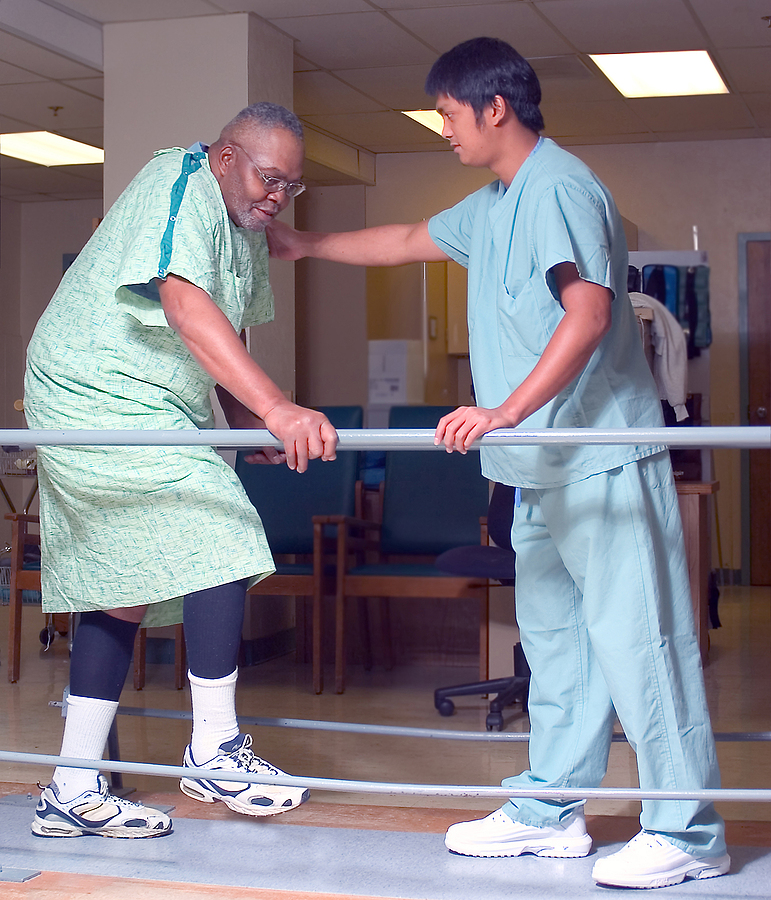 therapist help an older black man with his therapy.