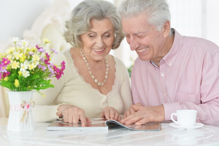 Senior couple smiling and reading.